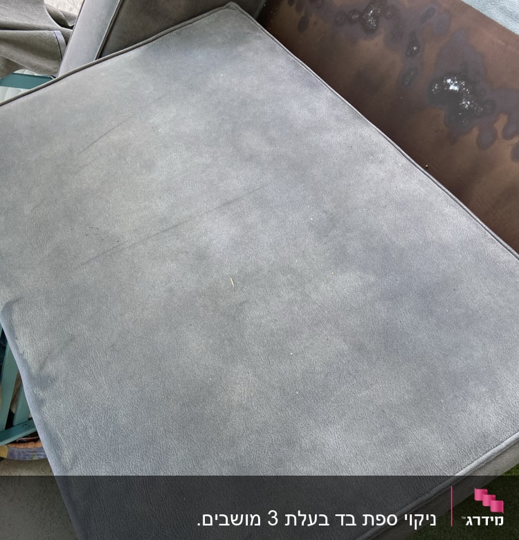 כרית ספה אפורה עם כתמים כהים